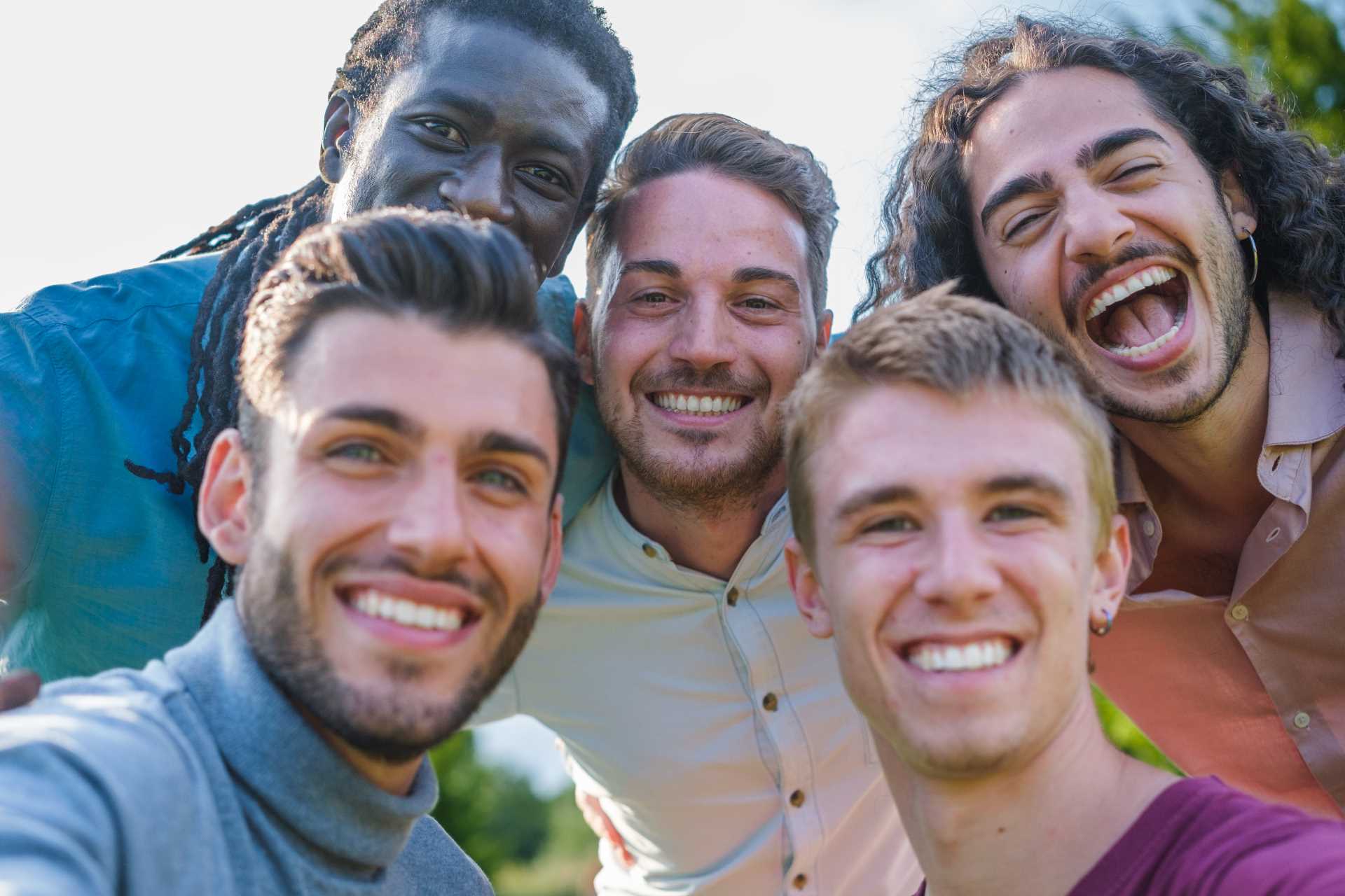 Group of men smiling at the camera | Featured image for the Men's Oral Health blog by Pearl Denture Studio.