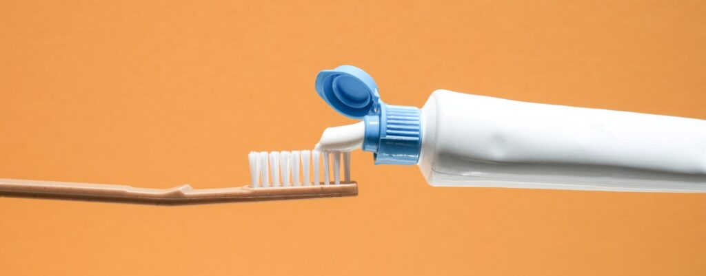 Toothpase and toothbrush | Featured image for the Toothpaste Myths & Misunderstandings blog by Pearl Denture Studio